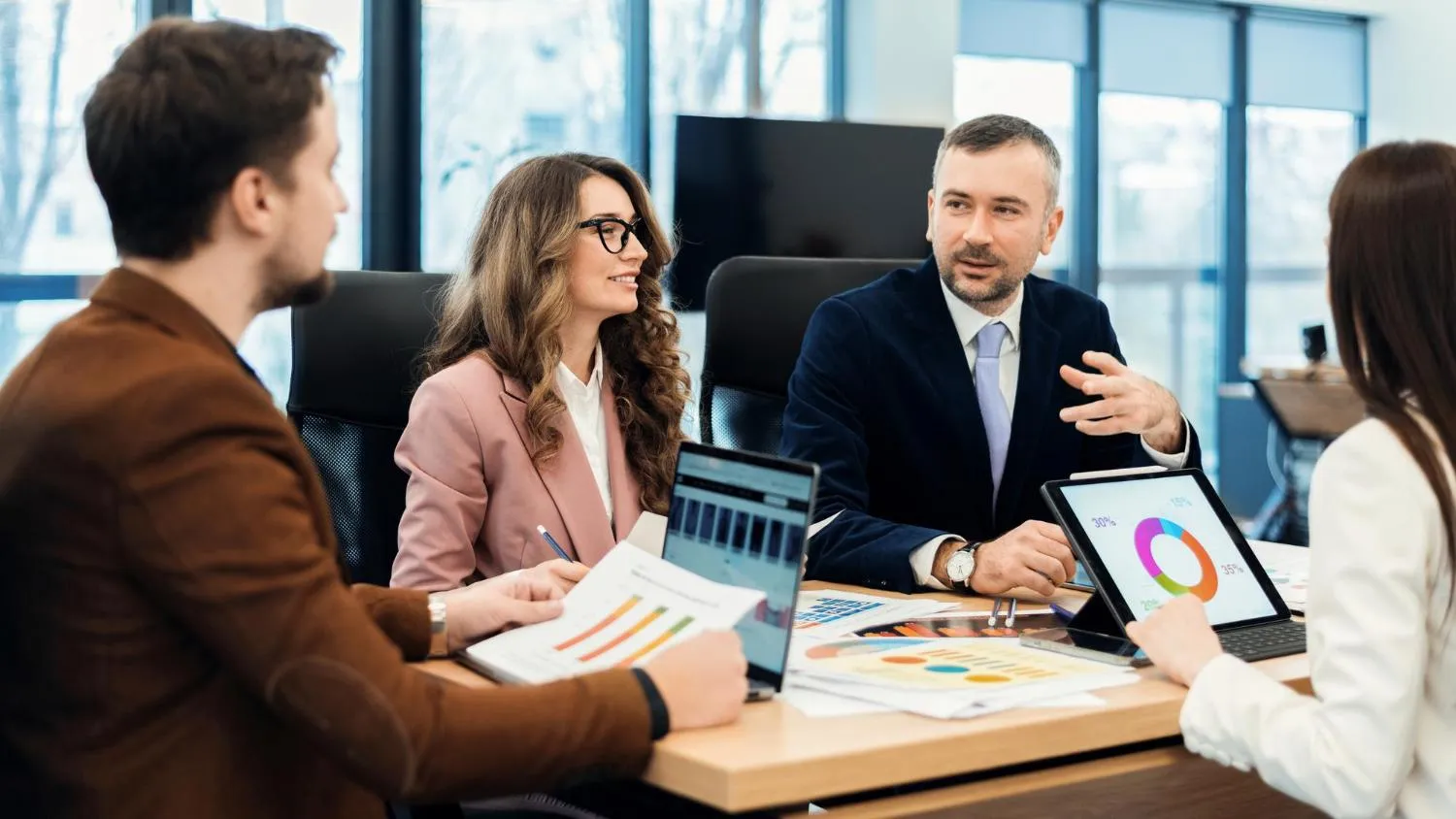 Consultants reviewing reports in a client meeting
