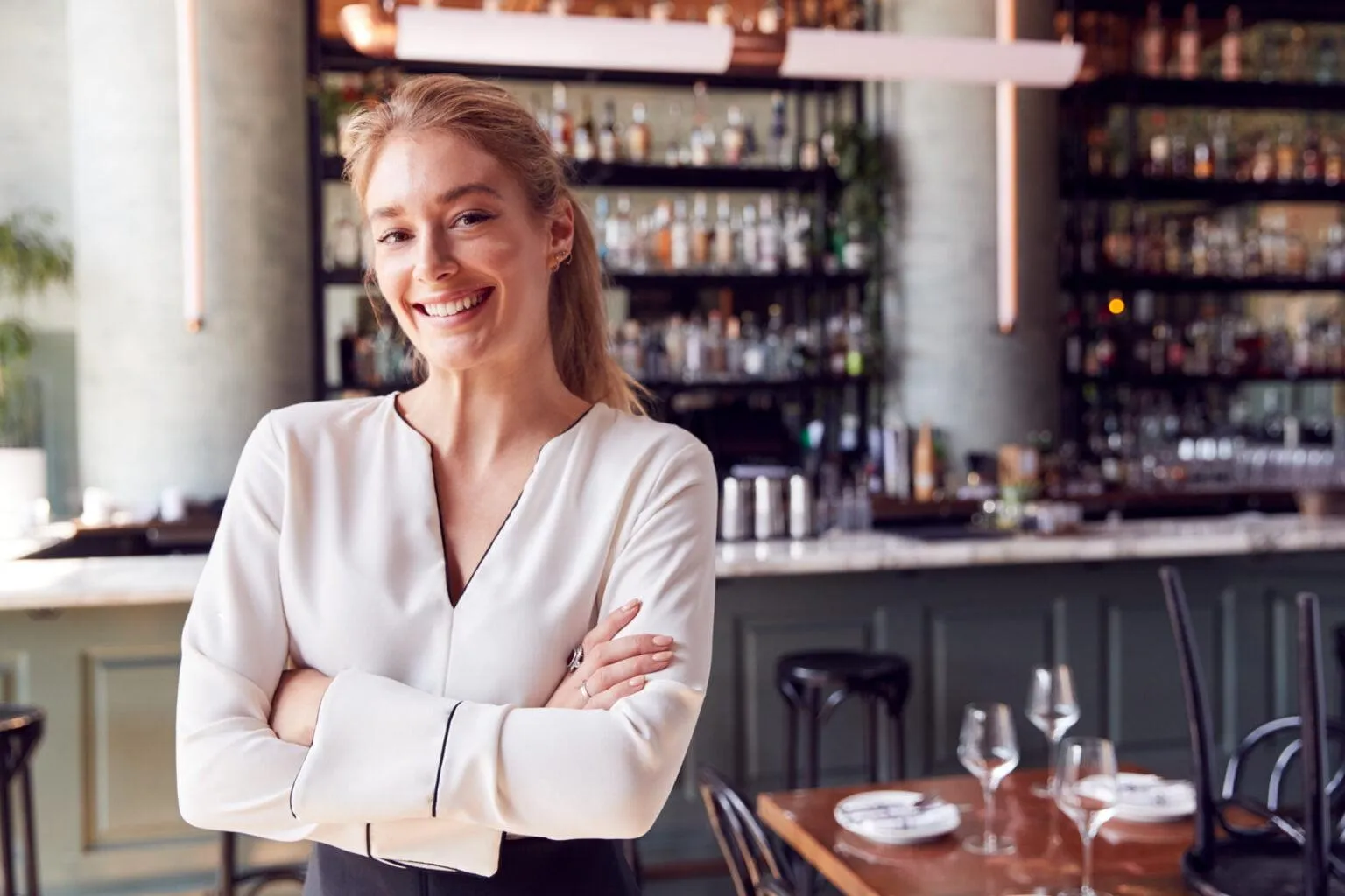 Hospitality worker smiling behind the restaurant bar