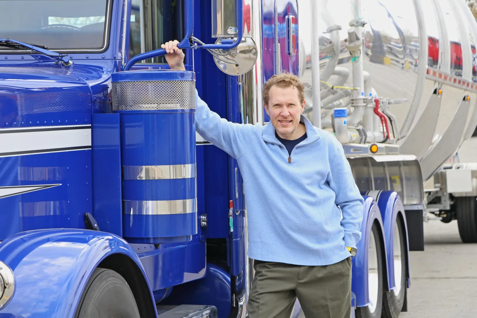 Owner-operator standing next to his semi truck