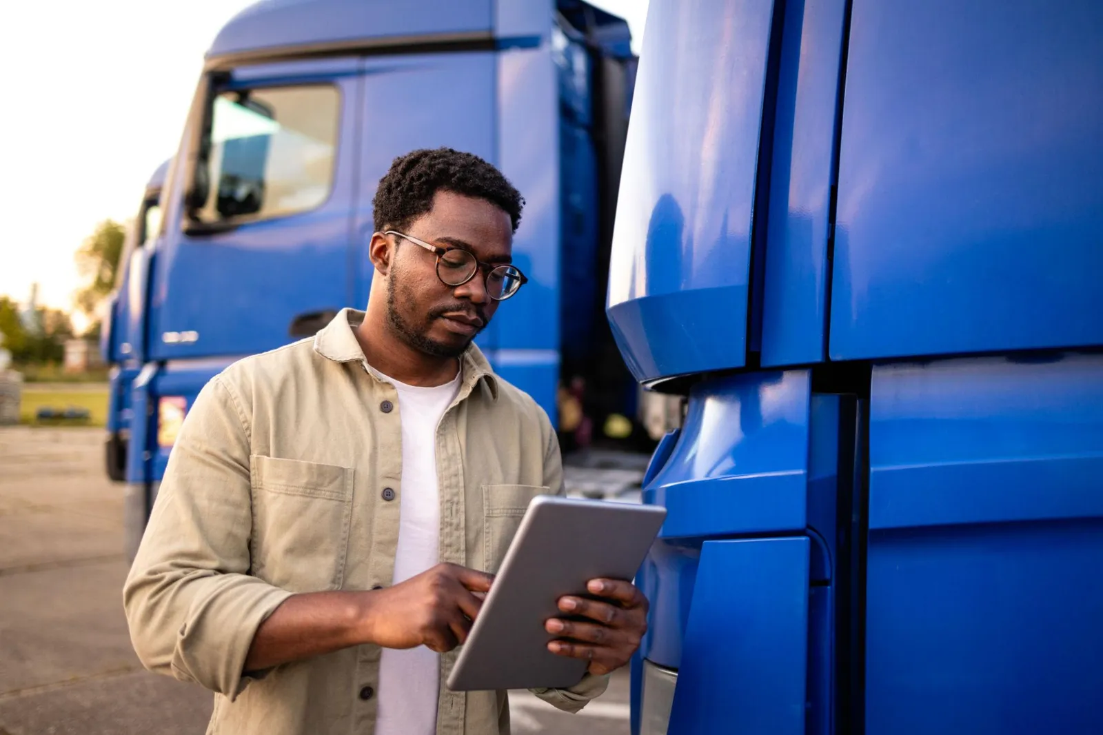 Truck driver reviewing details on a tablet beside his rig